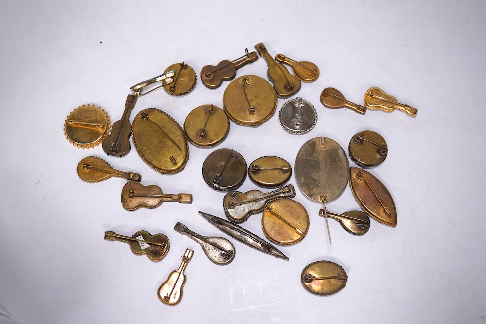 A collection of twenty-eight brooches, including fourteen mixed guitar and banjo shaped brooches, six large oval brooches, seven smaller brooches and one small oval., Condition - good